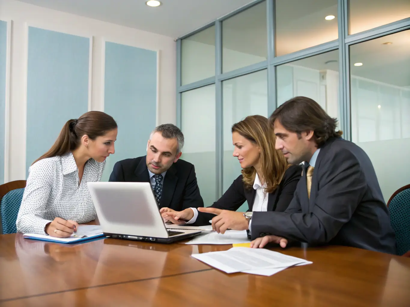 A photograph of a group of men participating in a mastermind session indoors, with Matt Paxson leading the discussion. The setting is professional and conducive to strategic planning and problem-solving.